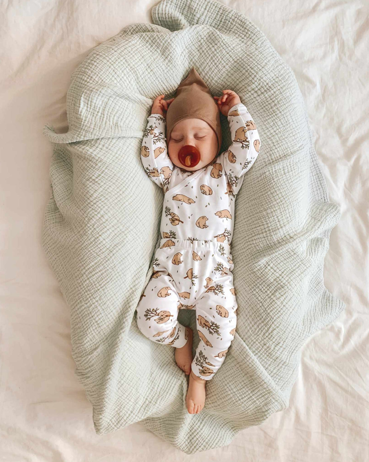 Baby in bear cub kimono bodysuit and leggings outfit on sage swaddle