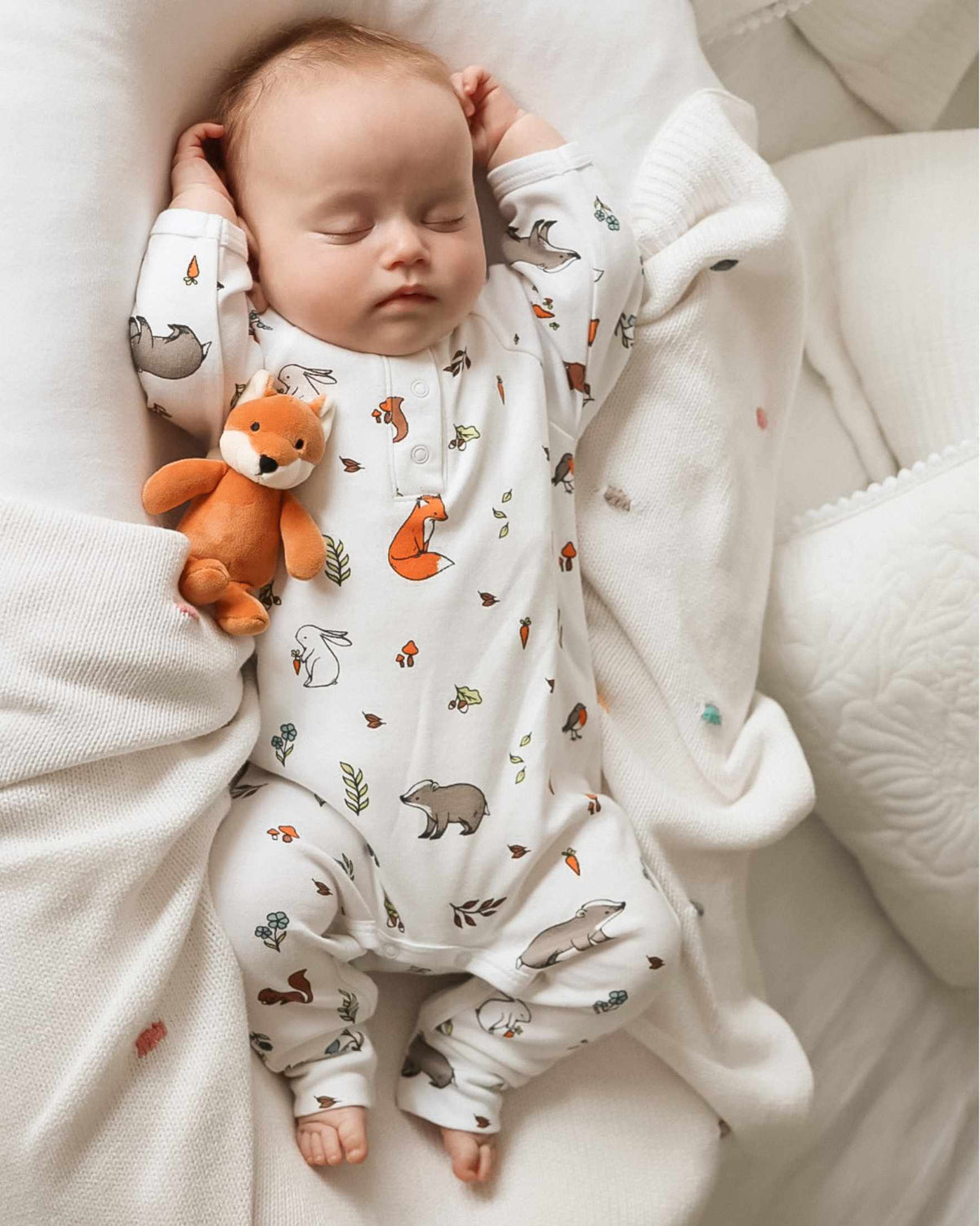 Baby sleeping in woodland organic cotton romper