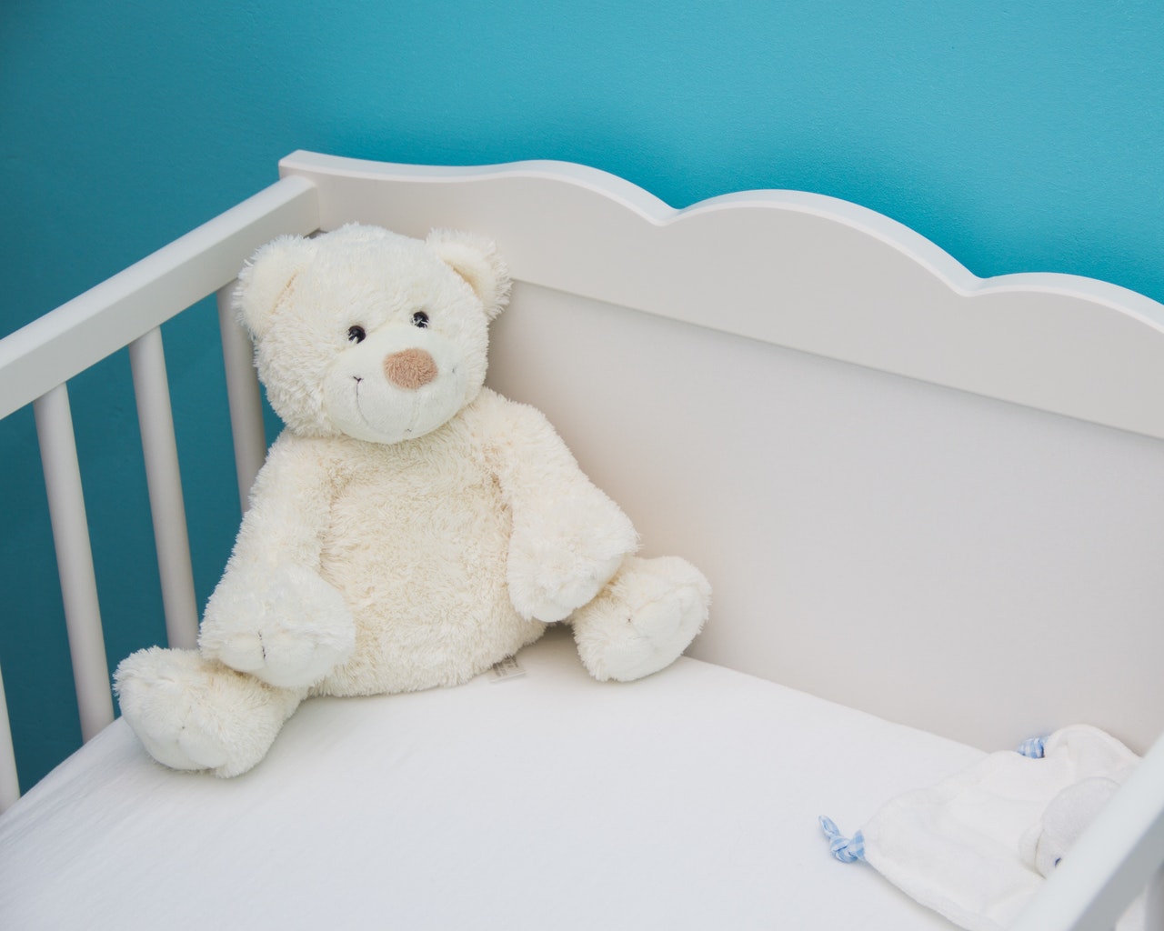 Swaddle or Sleeping Bag: White Teddy Bear in Baby Cot