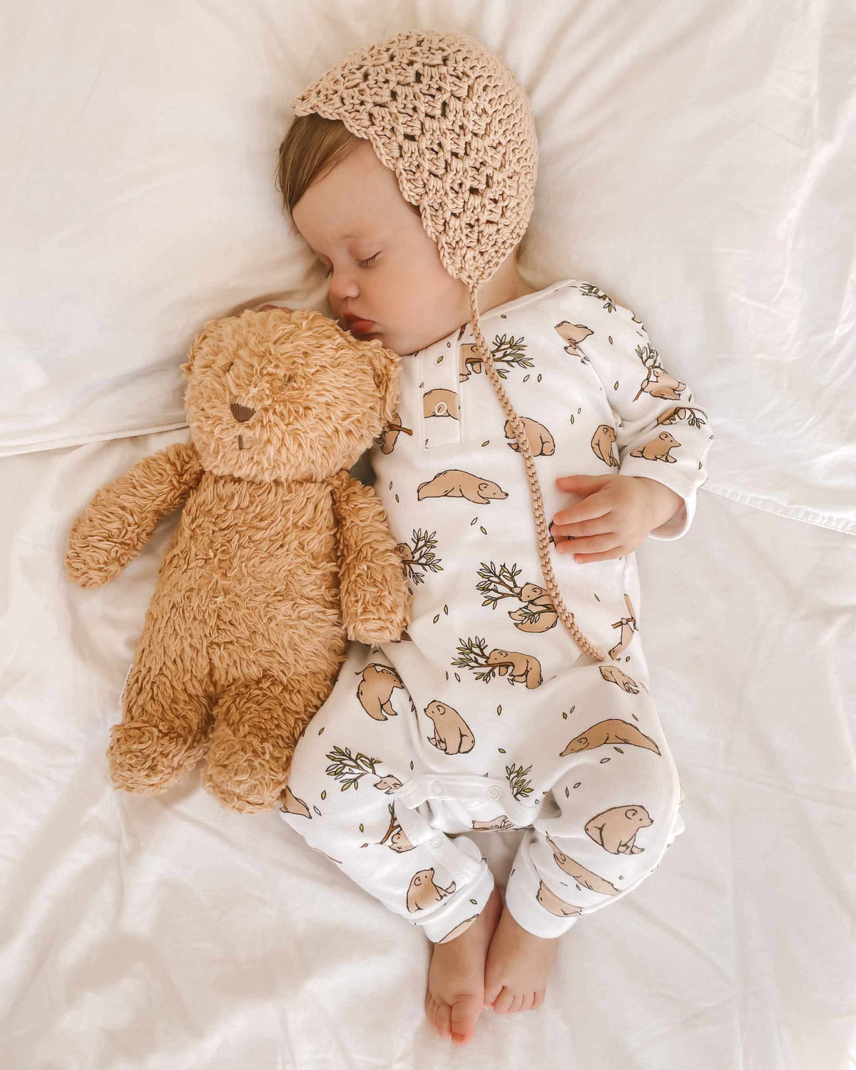 Baby in bear romper with teddy bear