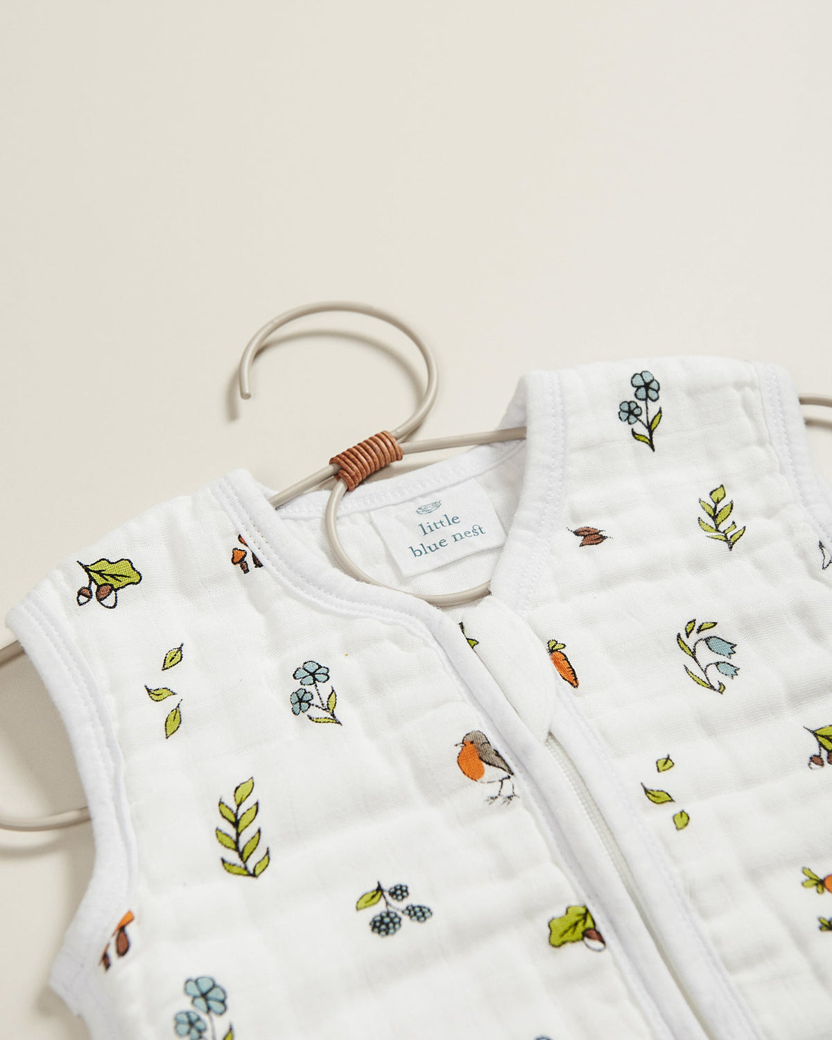 Organic cotton muslin baby sleeping bag 1.5 tog with woodland pattern on hanger